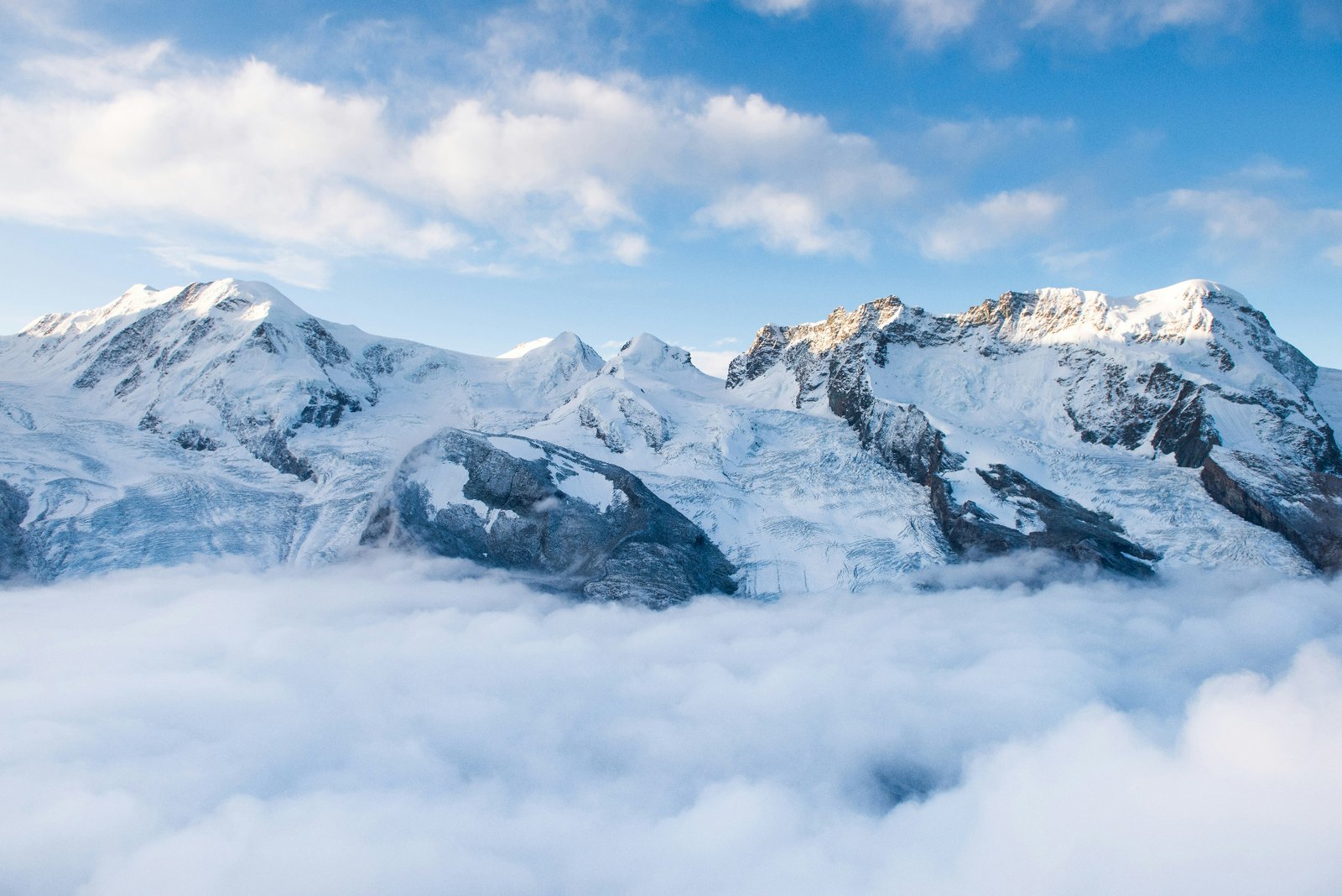 Snow-capped alpine peaks above a sea of clouds